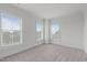 Bright bedroom with plush carpeting, three large windows, and neutral walls offers a serene atmosphere at 710 Independence Pl # 301, Raleigh, NC 27603