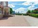 Brick paved courtyard with manicured hedges and a view of the city skyline at 710 Independence Pl # 301, Raleigh, NC 27603
