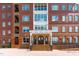 Building entrance featuring brick facade, stairs, accessible ramp, and well-manicured landscaping at 710 Independence Pl # 301, Raleigh, NC 27603