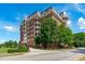 Brick multi-story building with balconies, a manicured lawn and blue skies at 710 Independence Pl # 301, Raleigh, NC 27603