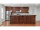 Well-equipped kitchen with stainless steel refrigerator, wooden cabinetry, granite countertop, and hardwood floors at 710 Independence Pl # 301, Raleigh, NC 27603