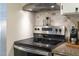 Modern kitchen stove top with stainless steel range hood and countertop at 7365 Sandy Creek Dr, Raleigh, NC 27615