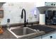 Close-up of kitchen sink with dark countertop and sleek black faucet at 7365 Sandy Creek Dr, Raleigh, NC 27615