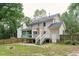 Exterior view of the house shows deck, large yard, and mature trees at 8116 Bentwood Pl, Raleigh, NC 27615