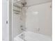 Tiled bathtub and shower featuring a shower caddy, handheld shower, and clean white tile at 8116 Bentwood Pl, Raleigh, NC 27615