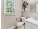 Bright bathroom featuring a white vanity, toilet, and a window with a view of the outdoors at 8116 Bentwood Pl, Raleigh, NC 27615