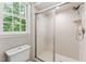 Bright bathroom featuring a tiled shower with glass door and a window offering natural light at 8116 Bentwood Pl, Raleigh, NC 27615