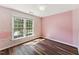 Bright bedroom features natural light, hardwood floors, and modern wallpaper with a large window at 8116 Bentwood Pl, Raleigh, NC 27615