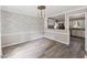Dining room with modern light fixture, accent wall, and view of kitchen, creating a warm gathering space at 8116 Bentwood Pl, Raleigh, NC 27615