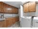 Functional laundry room featuring wooden cabinets, stylish countertops, and modern appliances at 821 Stoneybrook Dr, Sanford, NC 27330