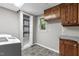 Laundry room includes washer, dryer, storage, cabinets, and tiled backsplash at 821 Stoneybrook Dr, Sanford, NC 27330