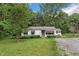Quaint one-story home featuring a well-manicured lawn, mature trees, and a gravel driveway at 8635 Old Us 421 S, Bear Creek, NC 27207