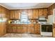A view of the kitchen with wooden cabinets, a window, and a vintage electric range at 8635 Old Us 421 S, Bear Creek, NC 27207