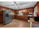Traditional kitchen with wooden cabinets, stainless steel refrigerator, and linoleum flooring at 8635 Old Us 421 S, Bear Creek, NC 27207