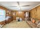 Spacious living room featuring cozy seating, wood paneling, and a ceiling fan at 8635 Old Us 421 S, Bear Creek, NC 27207