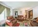 Cozy living room featuring matching leather seating, carpeted floors, and a bright window at 8635 Old Us 421 S, Bear Creek, NC 27207
