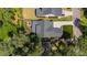 Aerial view of a home with a large roof, well-manicured lawn, brick patio, and surrounding lush greenery and trees at 911 Canterbury Rd, Raleigh, NC 27607