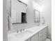 Bright bathroom featuring double sinks, quartz countertops, and decorative mirrors at 911 Canterbury Rd, Raleigh, NC 27607