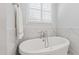 Stylish bathroom featuring a standalone soaking tub with marble tile surround and a window for natural light at 911 Canterbury Rd, Raleigh, NC 27607