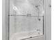 Bathroom with tiled bathtub and shower featuring glass door and shower caddy at 911 Canterbury Rd, Raleigh, NC 27607