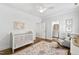 Cozy Bedroom design with a crib, chair, and adjoining bathroom, creating a peaceful and functional space at 911 Canterbury Rd, Raleigh, NC 27607
