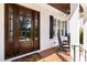 Close up of a front porch with a beautiful wood door, rocking chairs and ceiling fan at 911 Canterbury Rd, Raleigh, NC 27607