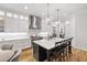 Modern kitchen featuring a large island with seating, stainless steel appliances, and designer lighting at 911 Canterbury Rd, Raleigh, NC 27607