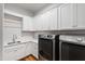 Well-equipped laundry room with sleek washer and dryer, ample cabinet space, and a convenient sink area at 911 Canterbury Rd, Raleigh, NC 27607