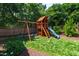 Backyard featuring a wooden playset with swings and a slide, perfect for outdoor activities and entertainment at 911 Canterbury Rd, Raleigh, NC 27607