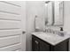 Stylish powder room with dark wood vanity, marble countertop, and modern mirror for added sophistication at 911 Canterbury Rd, Raleigh, NC 27607