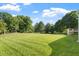 Expansive backyard with lush green grass and mature trees, providing ample space for outdoor activities at 9112 Mission Hills Ct, Raleigh, NC 27617