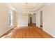 Formal dining room with hardwood floors, decorative chandelier, and large windows at 9112 Mission Hills Ct, Raleigh, NC 27617