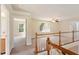 View of upper hallway with wood railing, multiple windows, and access to other rooms at 9112 Mission Hills Ct, Raleigh, NC 27617