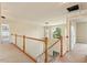 Loft area featuring a wooden railing, carpet, and large window with outdoor view at 9112 Mission Hills Ct, Raleigh, NC 27617