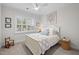 Charming bedroom features a white bed, natural light from the window, and decorative wall art at 1010 Sandbar Ln, Durham, NC 27703