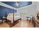 Spacious bedroom with four-poster bed, blue ceiling, and hardwood floors at 1010 Sandbar Ln, Durham, NC 27703