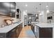 Modern kitchen featuring dark cabinetry, stainless steel appliances, and a large island with seating at 1010 Sandbar Ln, Durham, NC 27703