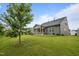 A picturesque backyard featuring a gray home with a screened porch and lush lawn at 1010 Sandbar Ln, Durham, NC 27703