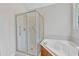 A pristine bathroom featuring a glass-enclosed shower and corner soaking tub at 103 Kylie Savannah Ct, Cary, NC 27511