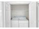 A laundry area with a white washer and dryer inside a closet behind folding doors at 103 Kylie Savannah Ct, Cary, NC 27511