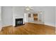 Living room featuring a classic fireplace, hardwood floors, and views into the adjacent kitchen area at 103 Kylie Savannah Ct, Cary, NC 27511