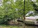 View of the home's backyard featuring lush trees, lawn, and a wooden deck area at 108 W Marsha Gayle Ct, Fuquay Varina, NC 27526