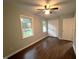 Bright bedroom featuring wood floors, a ceiling fan, two windows, and a closet at 108 W Marsha Gayle Ct, Fuquay Varina, NC 27526