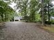 Well-maintained home exterior surrounded by large trees and a gravel driveway at 108 W Marsha Gayle Ct, Fuquay Varina, NC 27526