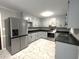 Bright kitchen boasts stainless steel appliances, grey cabinets and tile flooring at 108 W Marsha Gayle Ct, Fuquay Varina, NC 27526