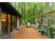 A view of a house's spacious back deck featuring outdoor seating with mature trees providing shade and privacy at 109 Loch Haven Ln, Cary, NC 27518