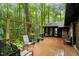A spacious wooden back deck with chairs, surrounded by greenery and trees, offering a peaceful outdoor retreat at 109 Loch Haven Ln, Cary, NC 27518