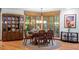 This well-lit dining room has a wood table with seating for six and a view to a wooded backyard at 109 Loch Haven Ln, Cary, NC 27518
