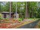 Side view of a brick house, surrounded by mature trees and landscaping with a paved driveway at 109 Loch Haven Ln, Cary, NC 27518