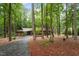Exterior view of the home nestled among mature trees, showcasing the long driveway and natural setting at 109 Loch Haven Ln, Cary, NC 27518
